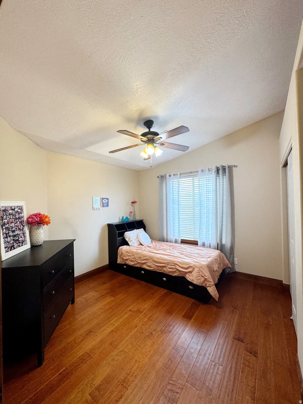 Vaulted ceiling with a ceiling fan, wood-finish flooring, and window with blinds
