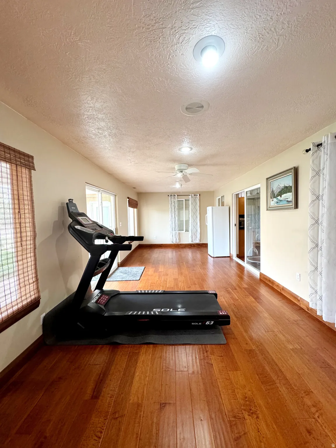 Expansive interior space featuring wood-finish flooring, recessed lighting, and a ceiling fan