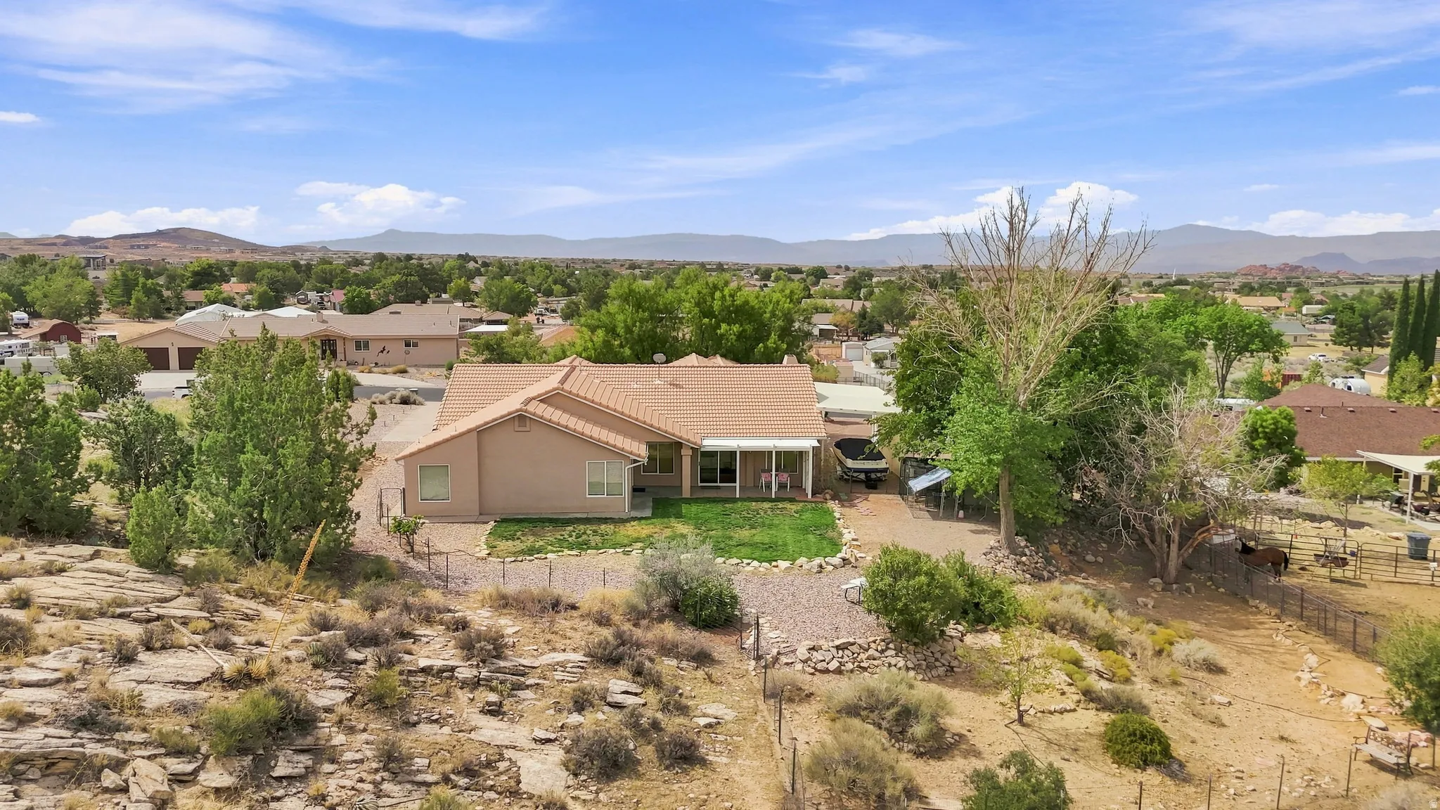 Single-story residence featuring a tile roof, covered patio, and a fenced perimeter
