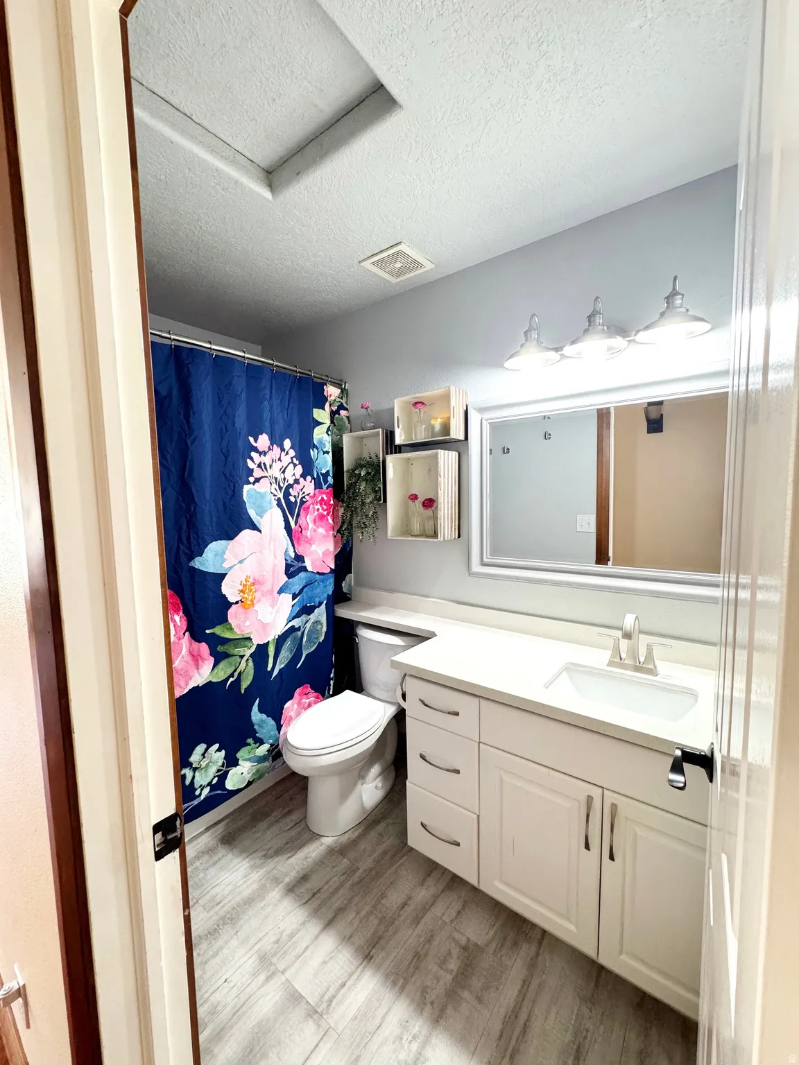 Contemporary bathroom featuring a white vanity with multiple storage drawers, quartz countertop, and brushed nickel fixtures