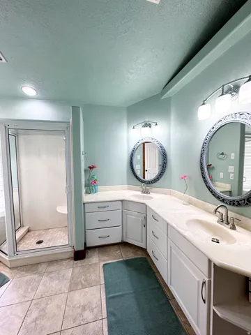 Dual vanity with undermount sinks, white cabinetry, and light-toned countertops