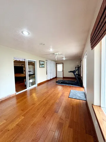 Hardwood flooring throughout, recessed lighting, ceiling fan, and sliding glass door
