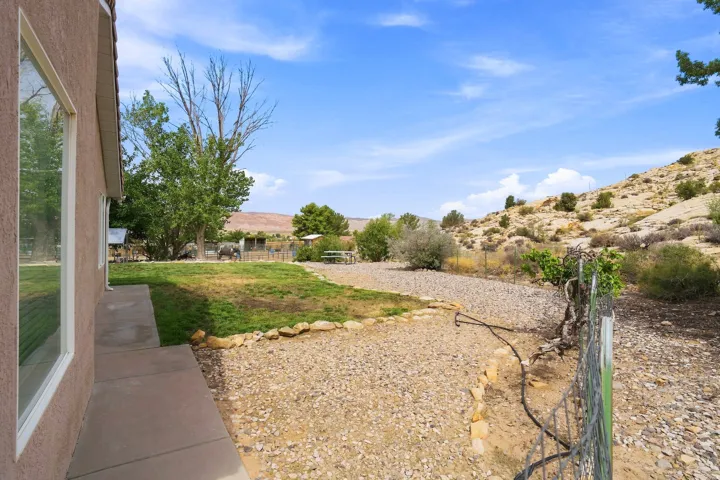 Expansive outdoor area featuring a combination of manicured lawn and gravel landscaping, with a concrete walkway bordering the building