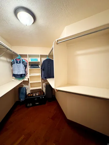 Walk-in closet featuring extensive built-in shelving and hanging rods