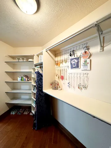 Built-in shelving, wood-finish flooring, overhead lighting, and white walls