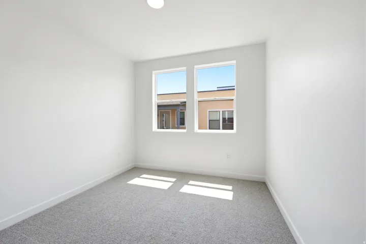 Bright room with light gray carpet, white walls, and a recessed ceiling light