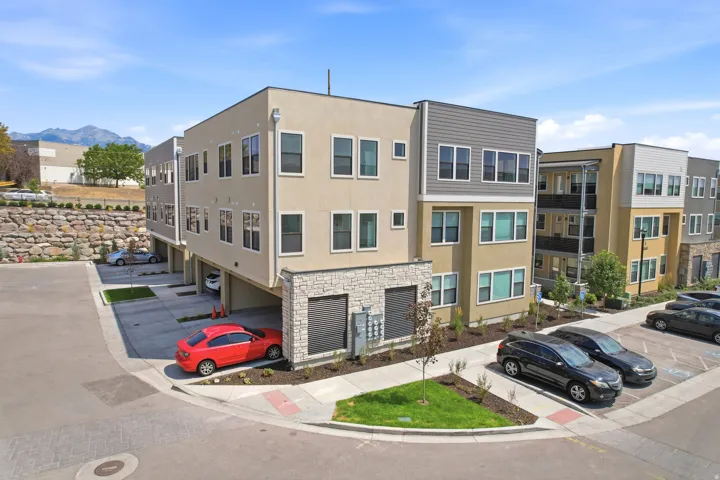 Multi-story residential building with contemporary siding, stone accents, and integrated garage spaces