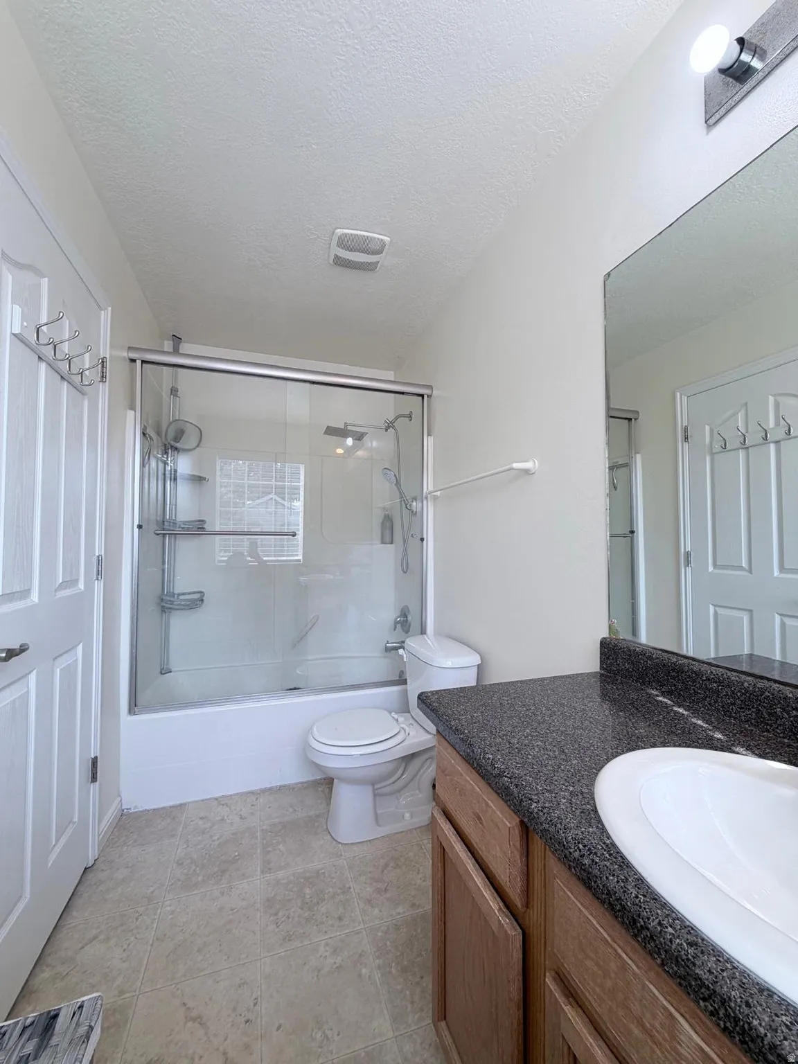 Wood-finish vanity with an integrated sink and dark speckled countertop