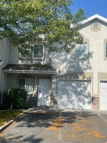 Two-story exterior with stucco siding and stone-finish accents