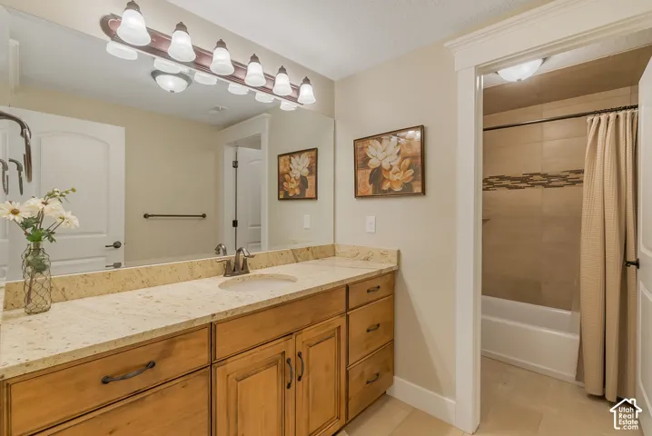 Granite-style countertop with an integrated sink, wood-finish vanity cabinetry, and a full-width mirror