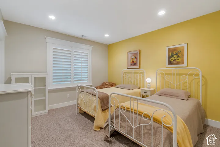 Recessed ceiling lighting, plantation shutters, white built-in cabinetry, and neutral carpet flooring