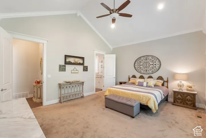Vaulted ceiling with crown molding, ceiling fan with integrated lighting, carpeted flooring, and a doorway leading to an adjoining space