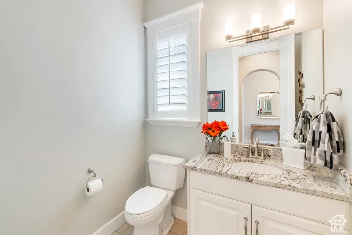 Elegant bathroom featuring a white vanity with dual sinks, granite-style countertop, and polished chrome fixtures