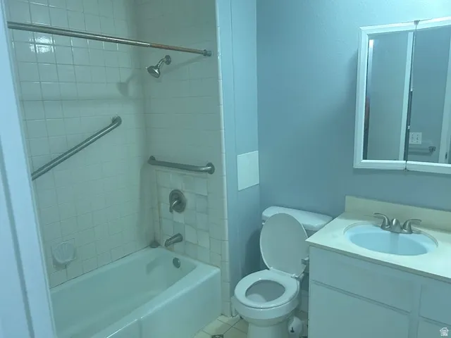 Shower with white tile surround, tub, and grab bars