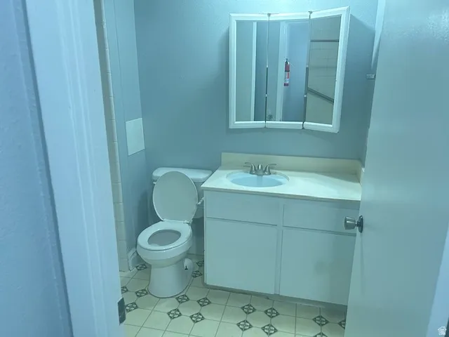 Vanity with integrated sink, tri-fold medicine cabinet, and patterned floor tile