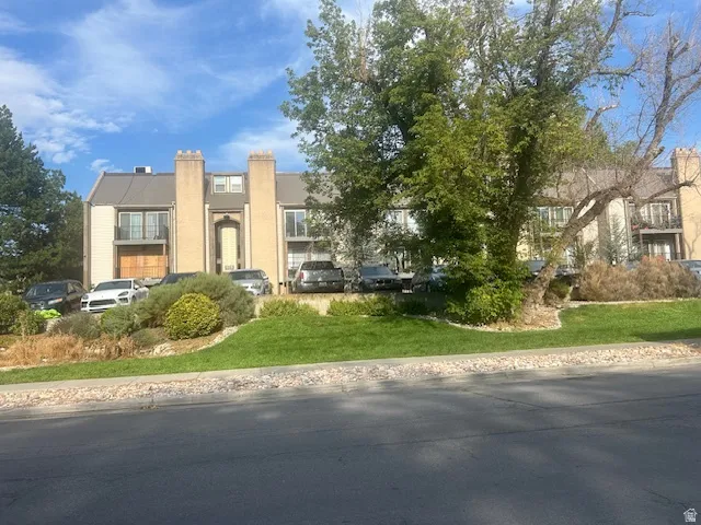 Multi-story building featuring balconies, dormer windows, and a prominent central arched entryway
