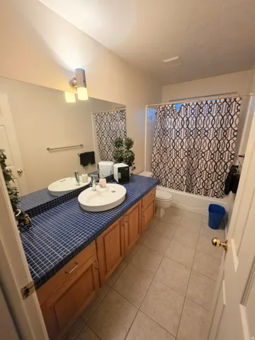 Dual vessel sinks on a blue mosaic tile countertop