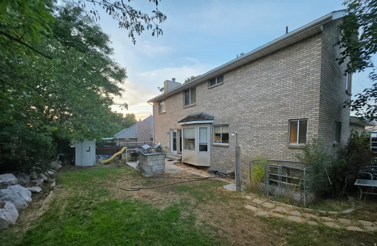 Brick exterior with multiple windows and a patio area
