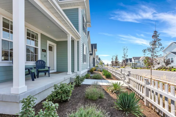 Expansive front porch with white columns, light blue siding, and white trim details