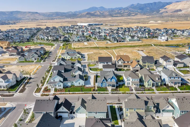 Expansive residential community with varied architectural styles, manicured landscaping, and mountain scenery