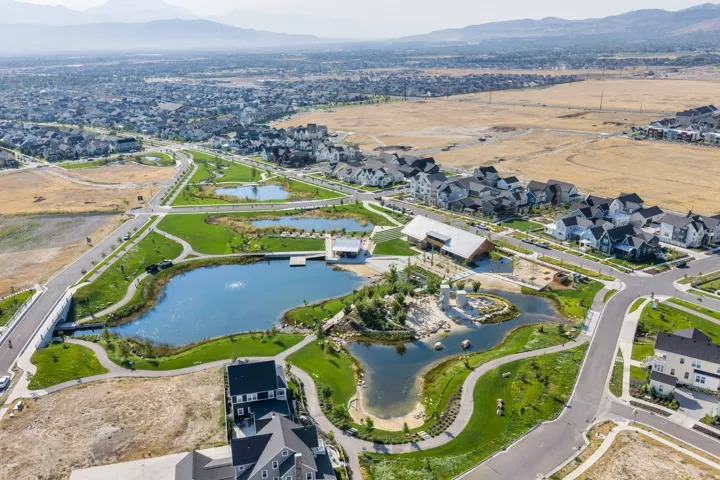 Community with multiple ponds, extensive green spaces, paved pathways, and a large recreational building