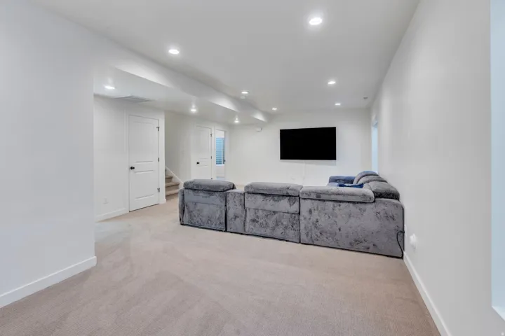 Recessed lighting illuminating a carpeted floor, white walls, and white trim