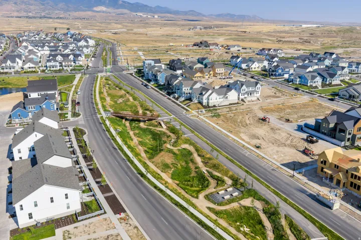 Expansive residential development with multiple completed and under-construction properties, paved roads, and integrated green spaces
