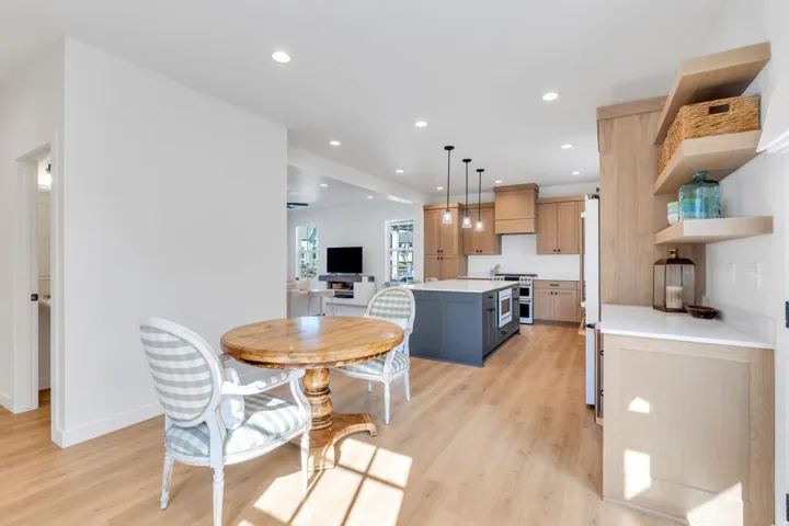 Kitchen featuring a central island with built-in microwave, wood-finish cabinetry, stainless steel appliances, and pendant lighting