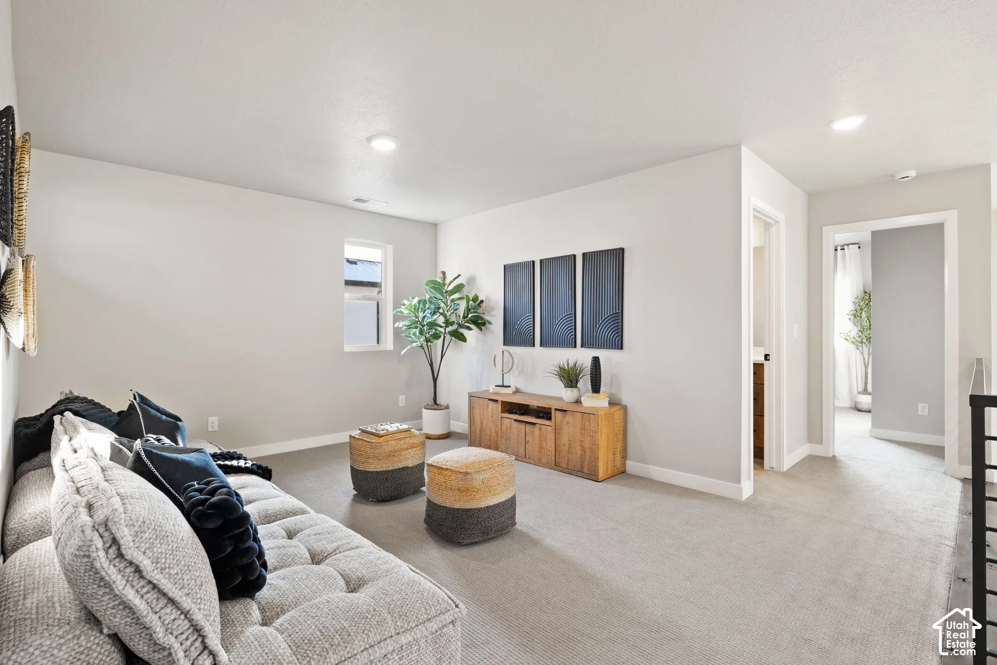 Recessed lighting illuminates the carpeted floor and light-toned walls