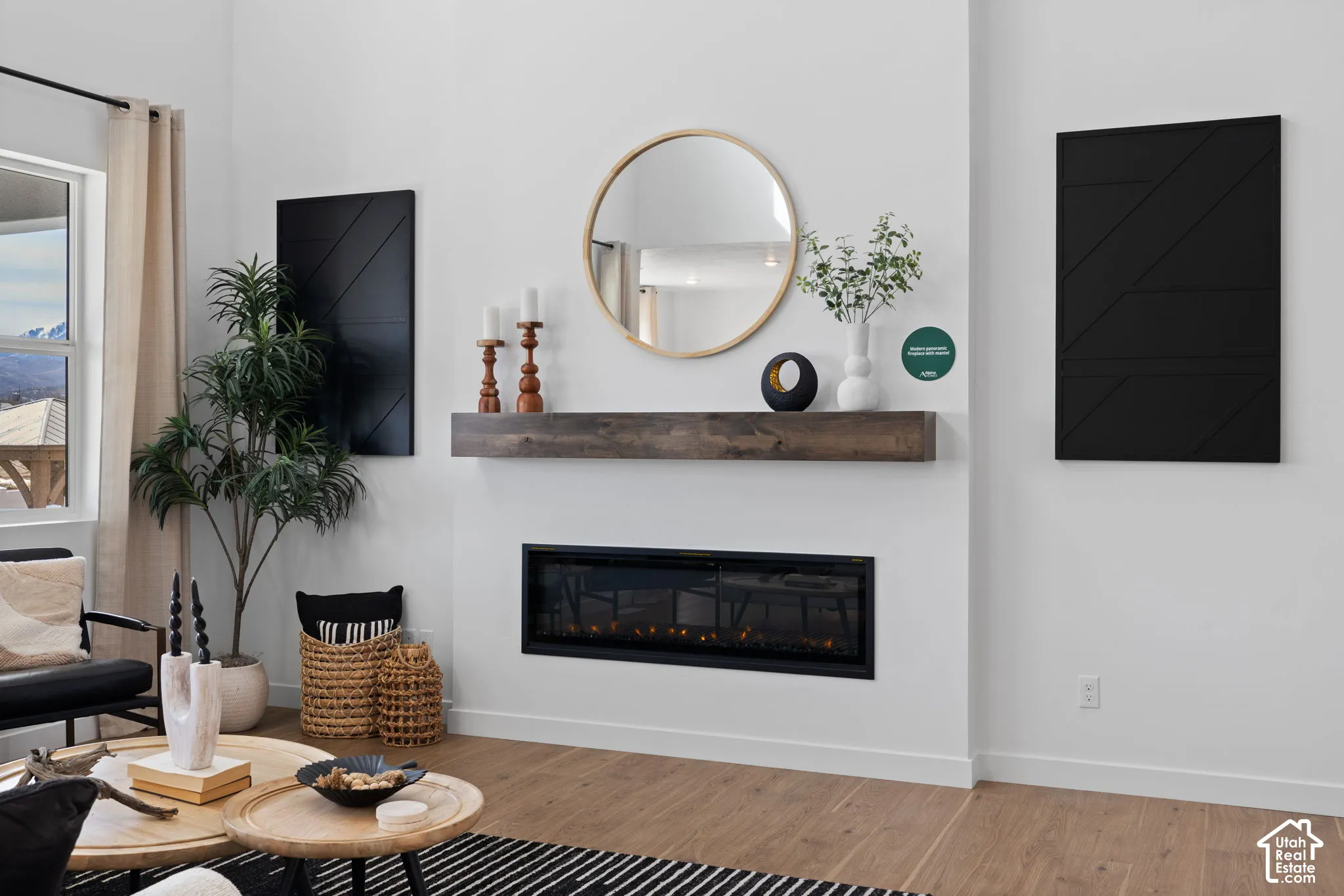 White walls with wood-finish flooring, a linear electric fireplace, and a wood mantel