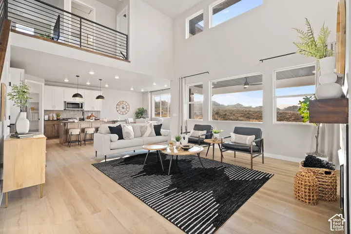 Spacious living area with wood-finish flooring, high ceilings, and extensive window placement