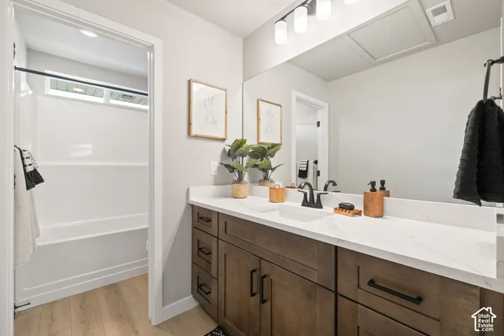 Dual undermount sinks with matte black faucets, wood-finish cabinetry, and white countertops