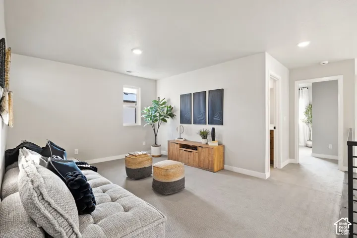 Recessed lighting illuminates the carpeted floor and light-toned walls