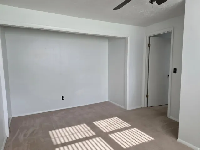 Bright, open bedroom featuring wood-finish flooring, recessed ceiling lighting, and abundant natural light from large windows