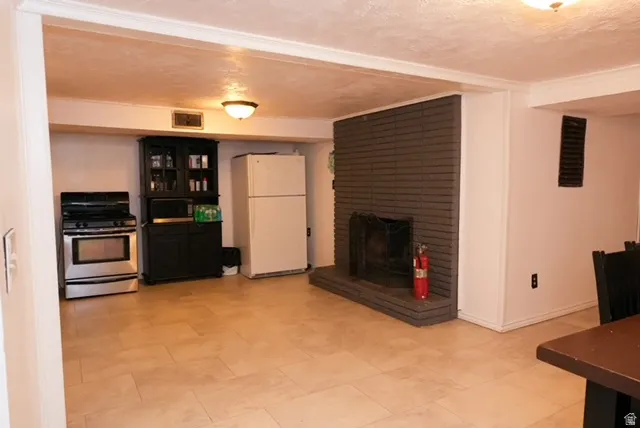 Spacious room featuring tile flooring, a fireplace with a brick surround, and a built-in black cabinet