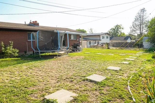 Expansive lawn with concrete stepping stones leading to a brick exterior