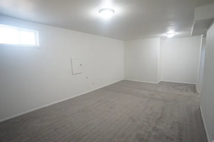 Neutral wall paint, plush carpeting, built-in ceiling lighting, and a transom window