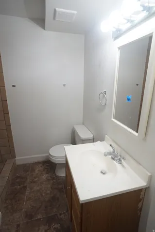 Vanity with integrated sink, wood-finish cabinetry, and chrome-finish faucet