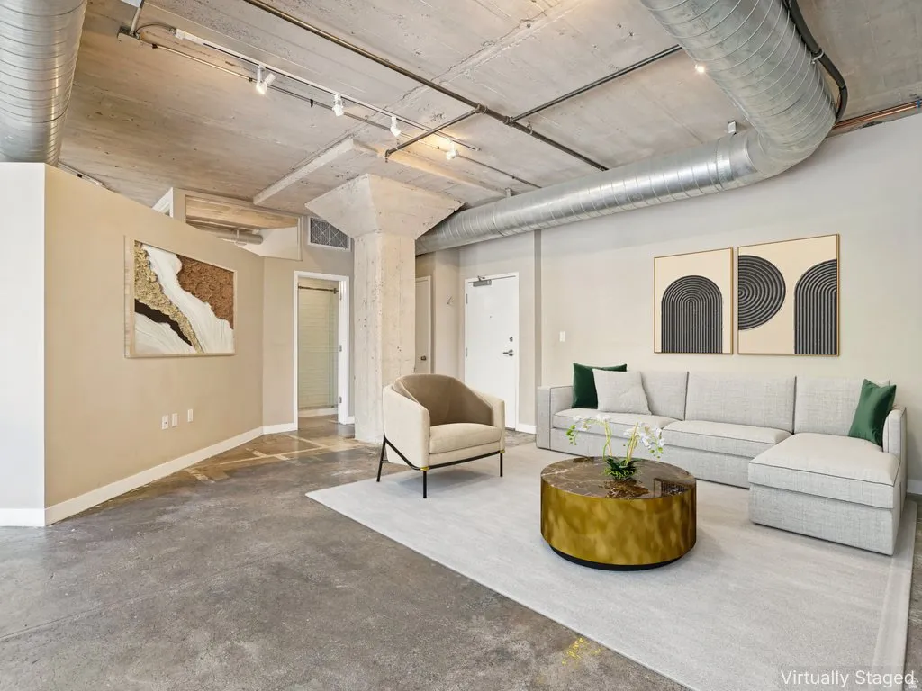 Polished concrete flooring, exposed concrete ceiling, industrial-style ductwork, structural concrete columns, and track lighting