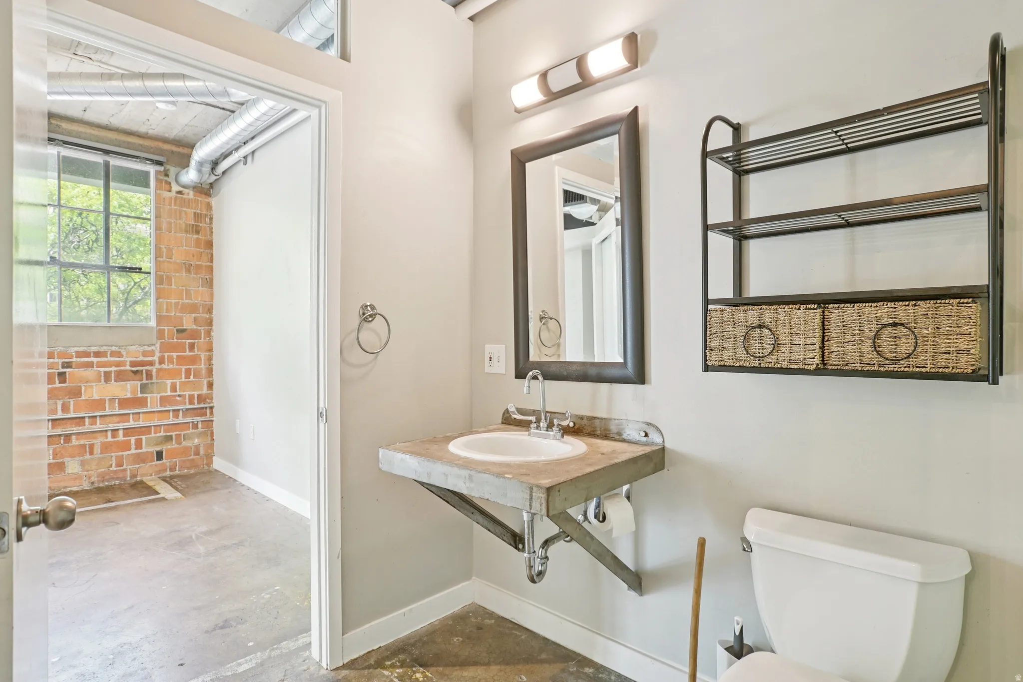 Wall-mounted vanity with integrated sink, rectangular mirror, and overhead lighting