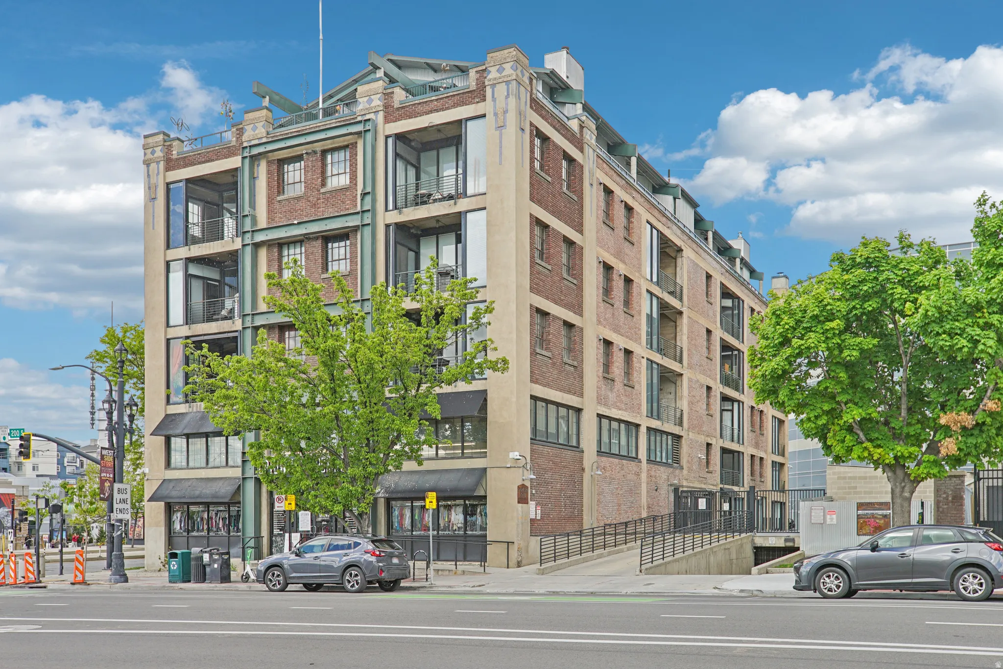 Multi-story building featuring brick and stucco facade, prominent window lines, and multiple balconies