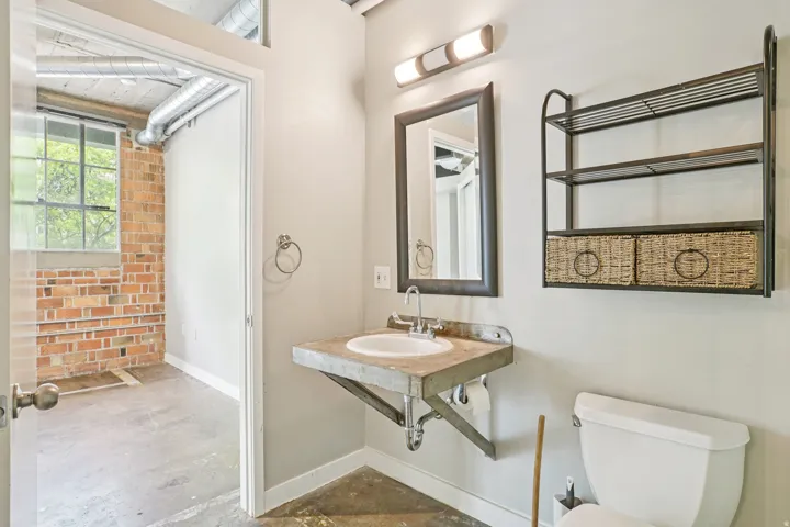 Wall-mounted vanity with integrated sink, rectangular mirror, and overhead lighting