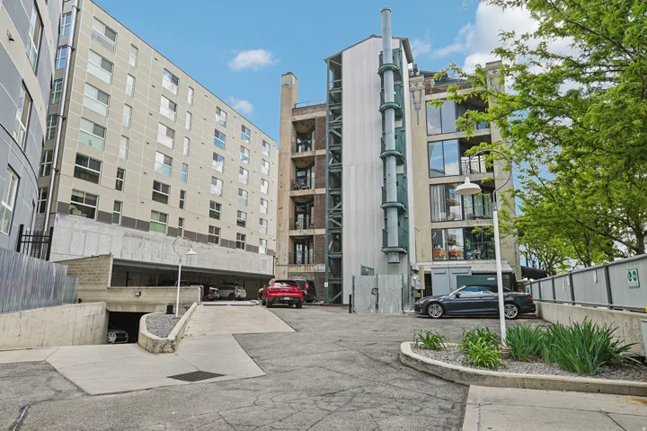 Underground parking garage entrance with a concrete ramp and mature landscaping