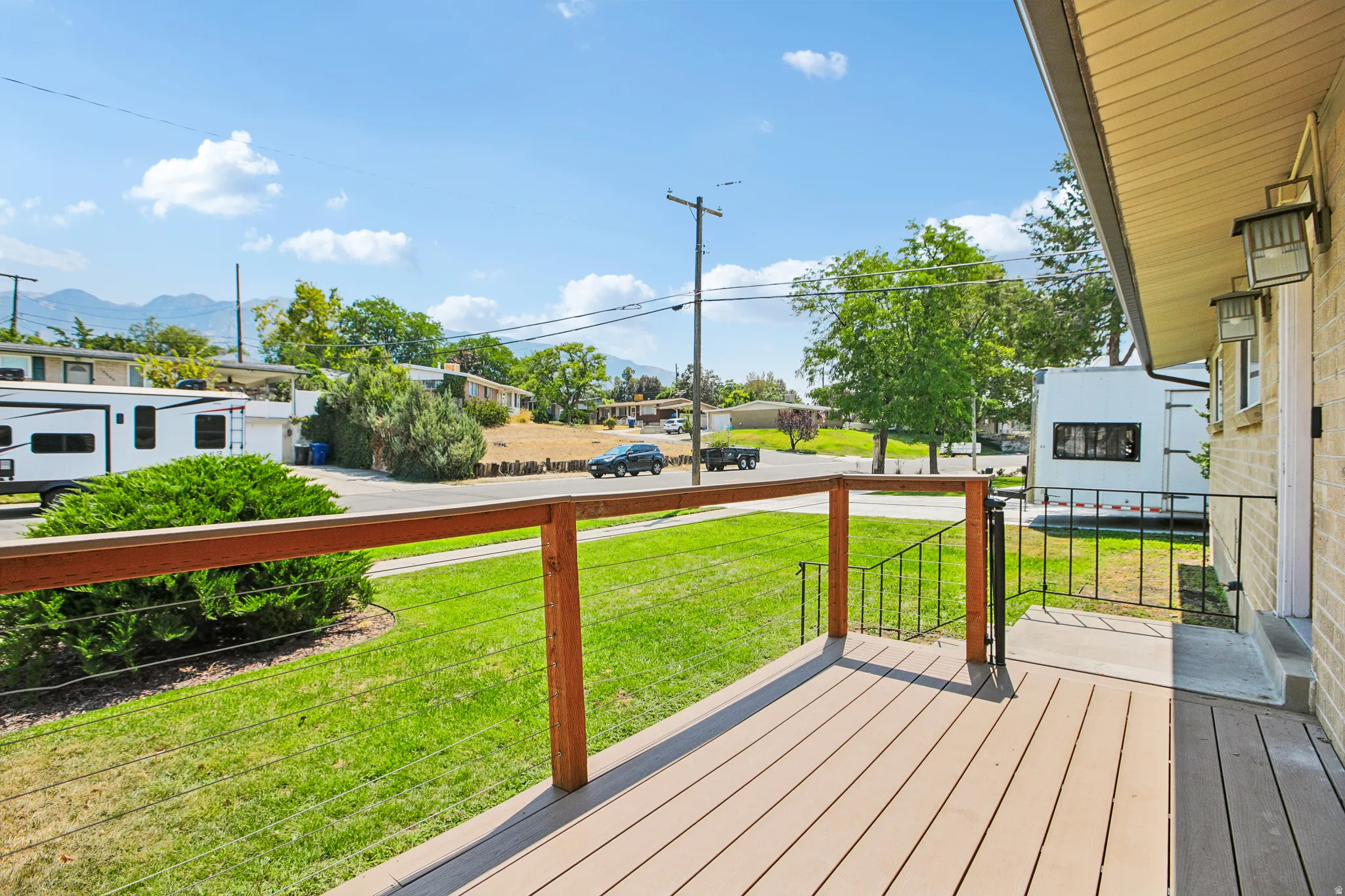 Deck with composite wood-finish surface, wood railing, and cable infill