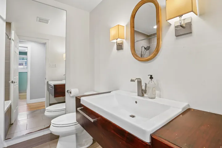 Floating wood-finish vanity with an integrated rectangular sink and brushed nickel faucet