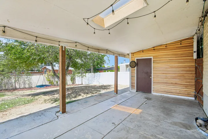 Covered patio featuring a skylight, wood-look siding, and a concrete slab floor