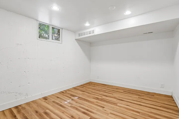 Recessed lighting, wood-finish flooring, and white painted walls