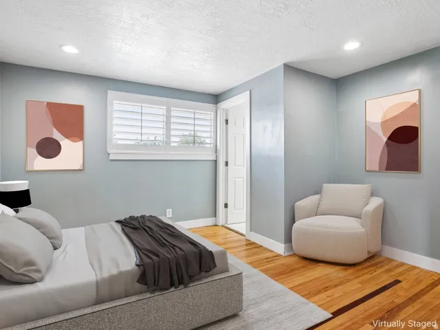 Hardwood flooring, recessed lighting, white window shutters, and a paneled interior door