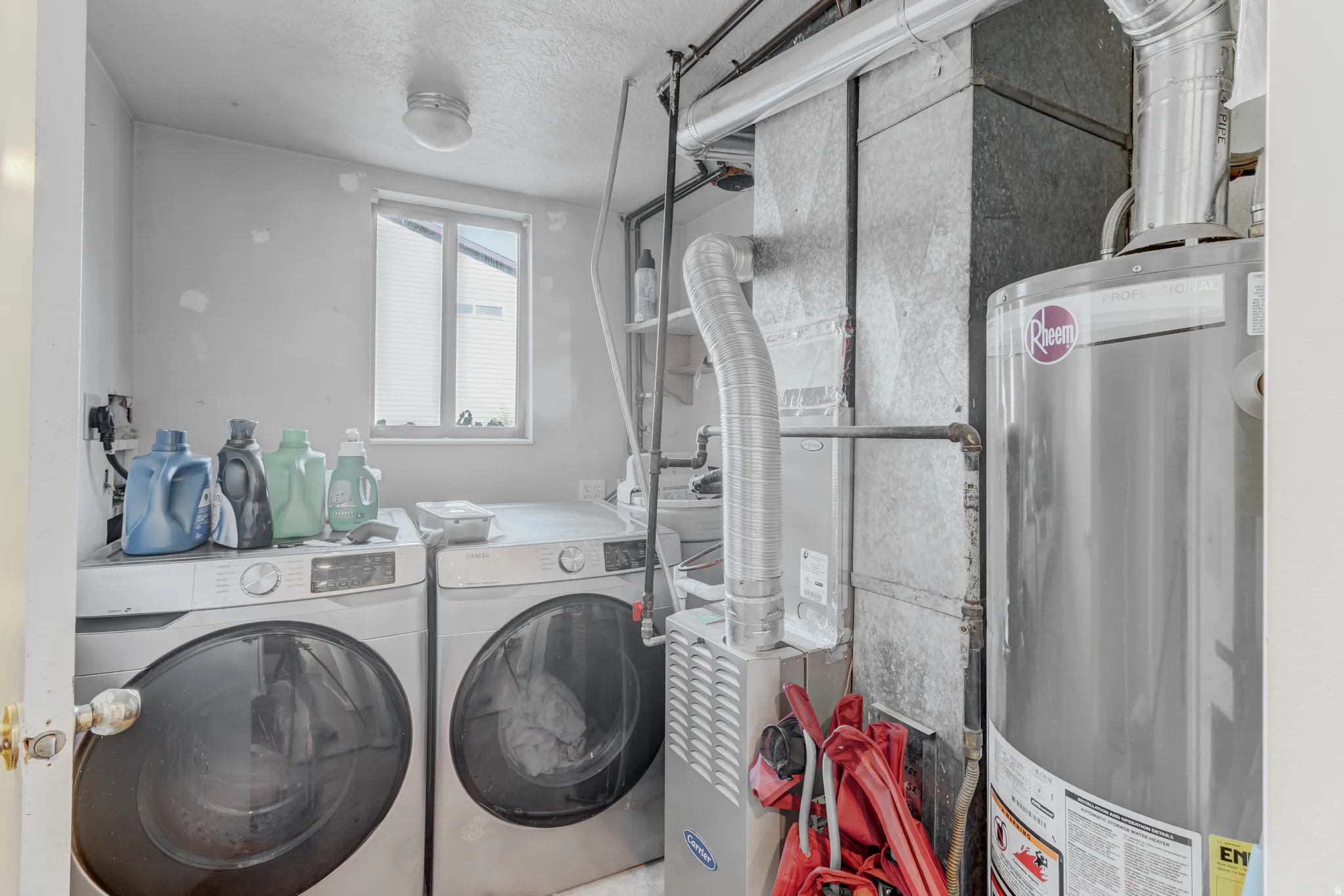 Utility room featuring a water heater, furnace, and a window