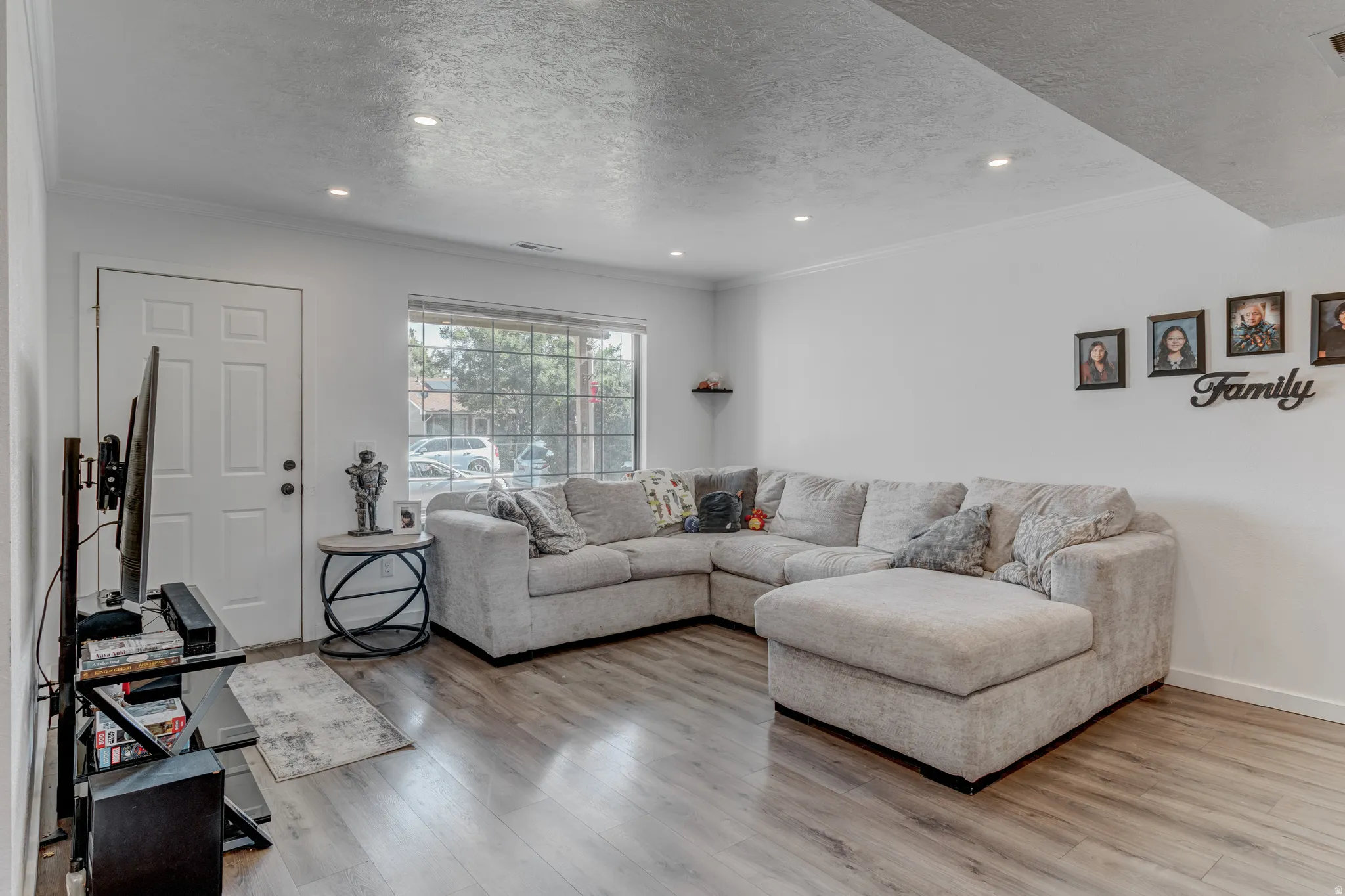 Recessed ceiling lighting, wood-finish flooring, white walls, and a multi-pane window